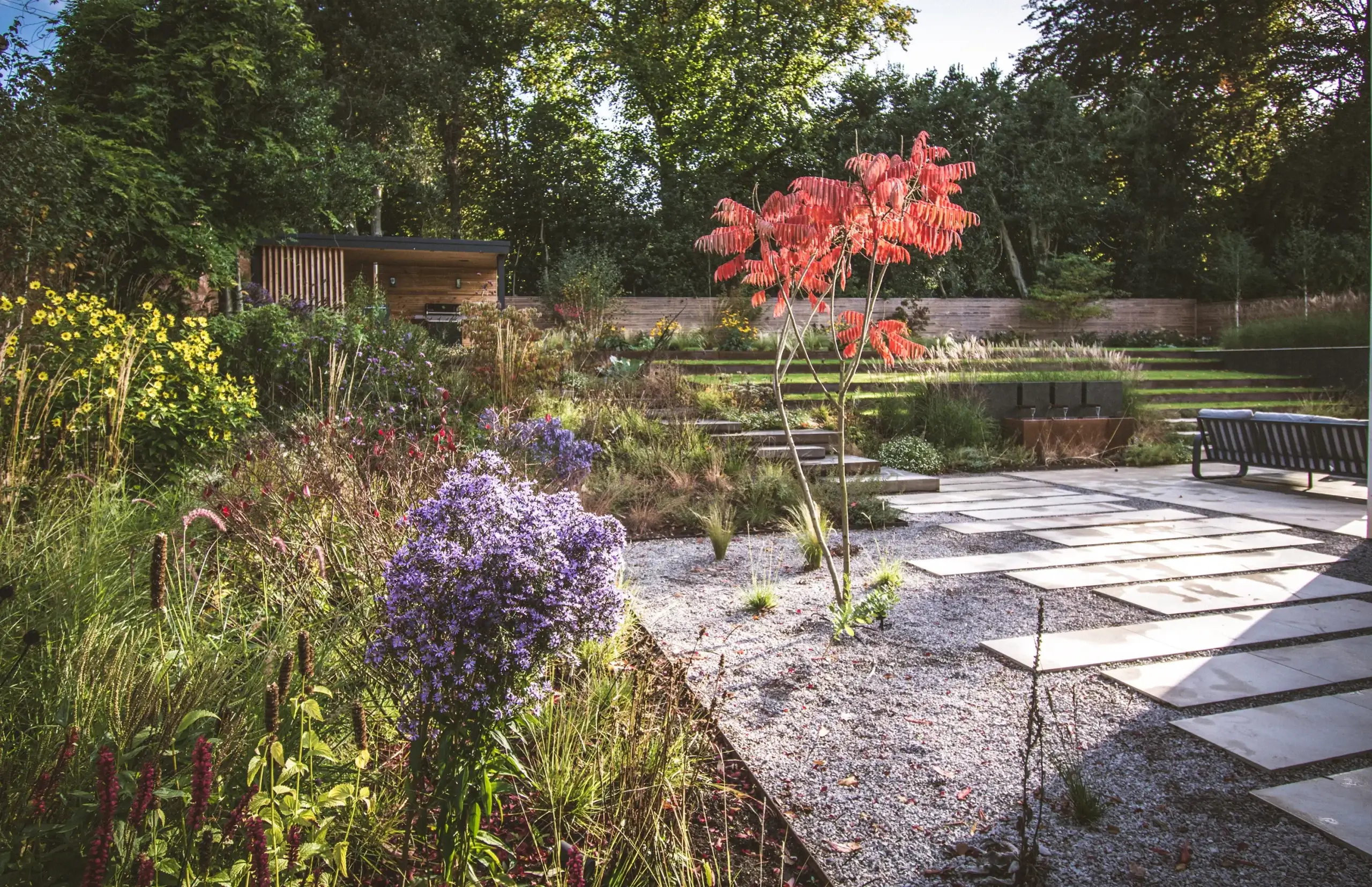 Garden with bold foliage and layered naturalistic planting.