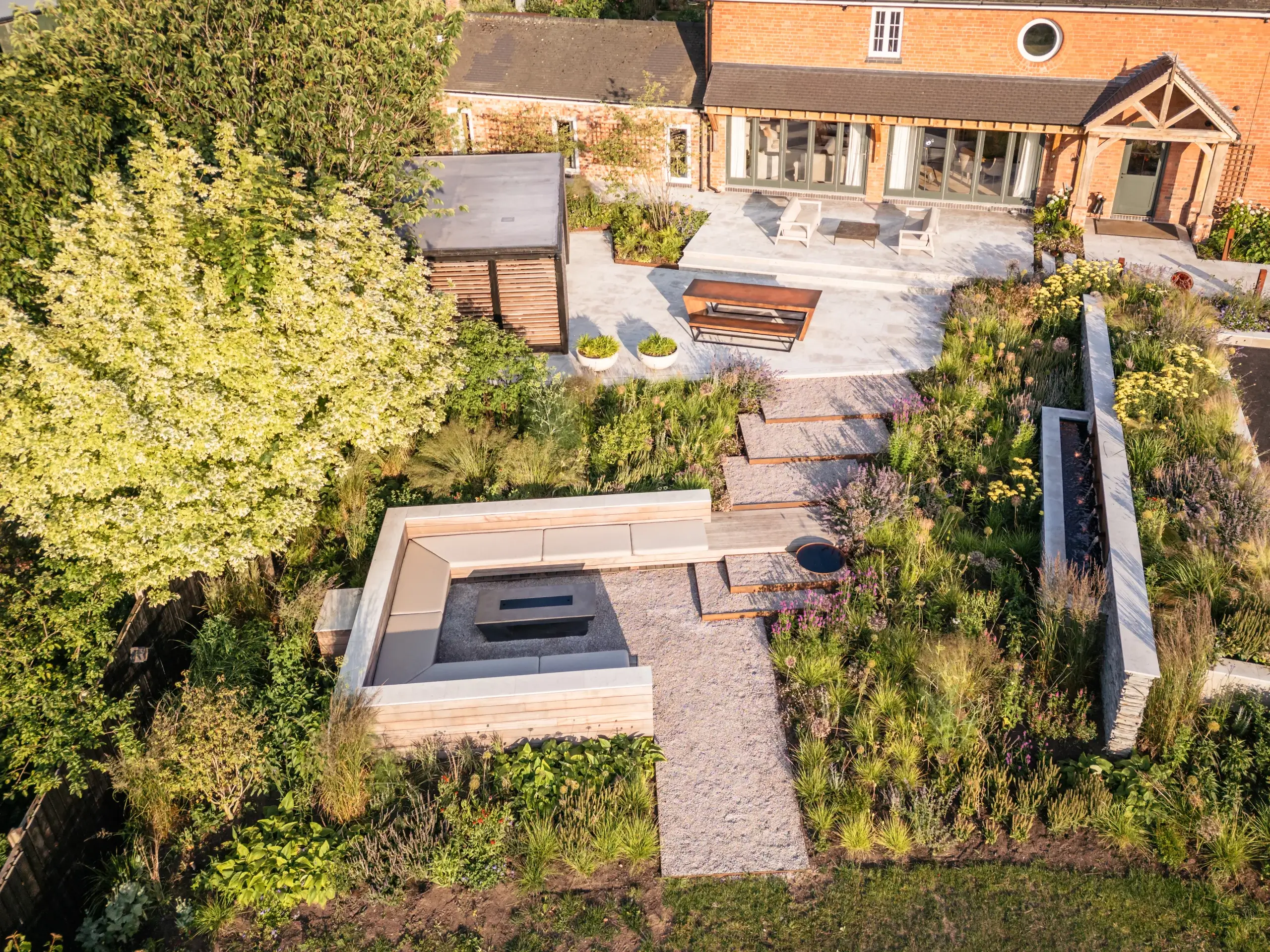Garden overview with tiered planting and seating area.