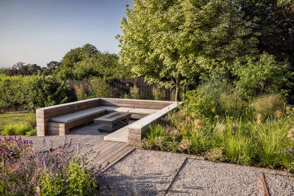 Garden seating with wraparound timber bench and soft planting.