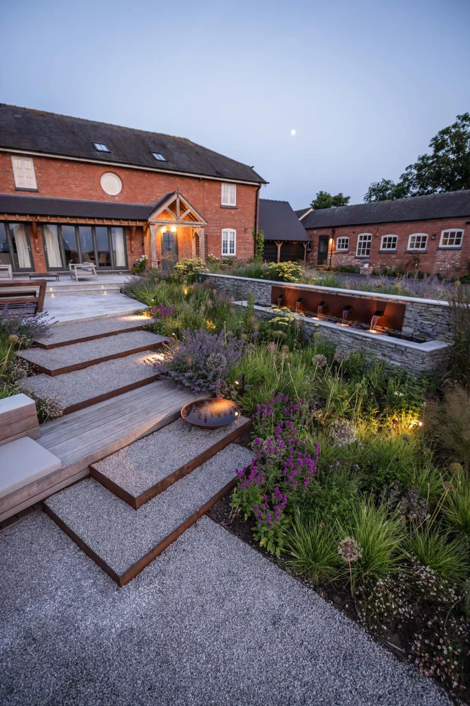 Gravel garden steps with water feature and layered planting.